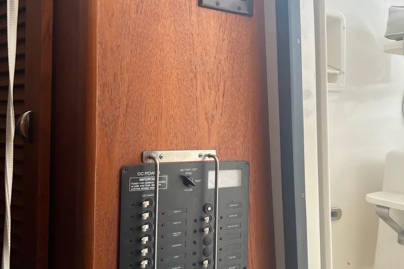 Slide: The Image of Control panel on 2001 Pursuit 3000 Offshore boat, featuring wooden finish and switches. - 6