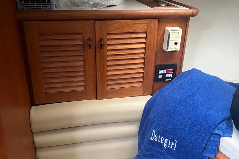 Slide: The Image of 2001 Pursuit 3000 Offshore cabin with wooden cabinets and blue towel. - 7
