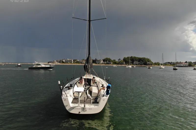 Slide: The Image of 2013 J Boats J/122 sailboat in a scenic harbor under a dramatic sky. - 13