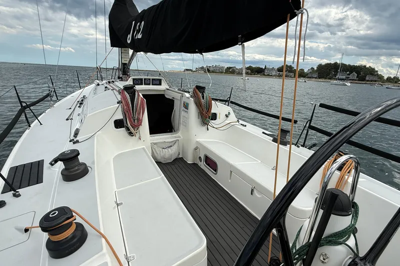 Slide: The Image of 2013 J Boats J/122 sailboat cockpit with ropes, winches, and open cabin on calm water. - 20