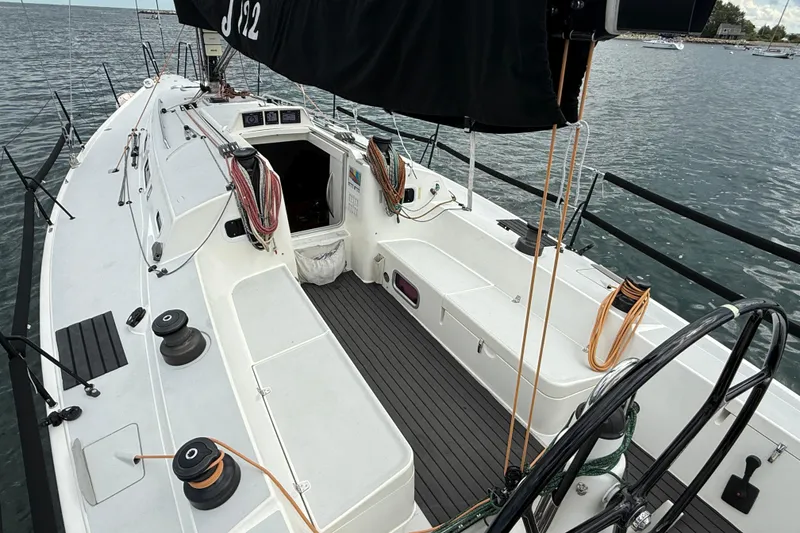Slide: The Image of 2013 J Boats J/122 sailboat cockpit with ropes and steering wheel on calm water. - 21