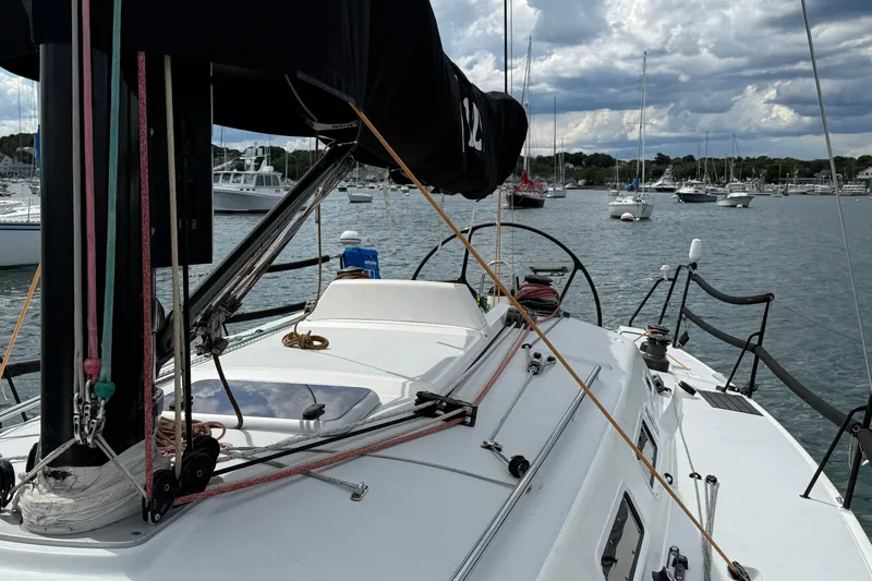 Slide: The Image of 2013 J Boats J/122 sailboat deck with rigging, docked in a marina under cloudy skies. - 28