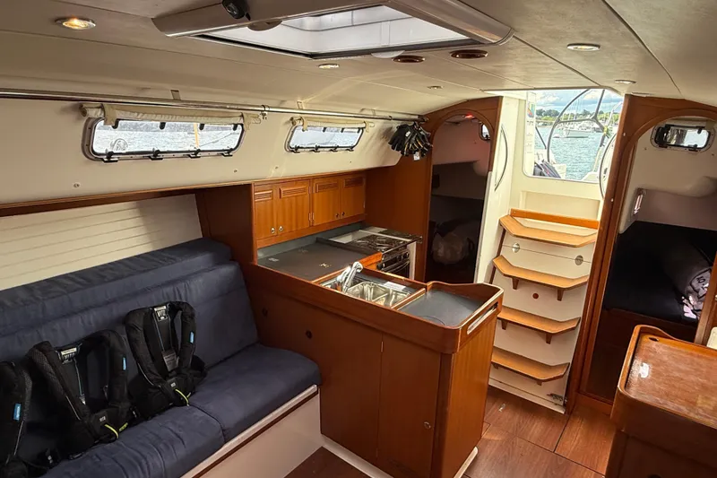 Slide: The Image of Interior of 2013 J Boats J/122 sailboat with cozy seating and wooden cabinetry. - 43