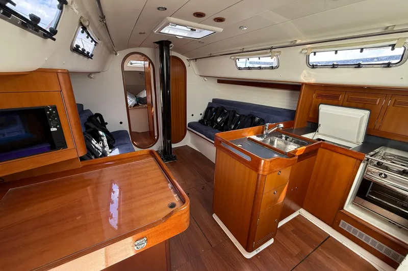 Slide: The Image of Interior of 2013 J Boats J/122 sailboat with wood finish and compact kitchen area. - 45