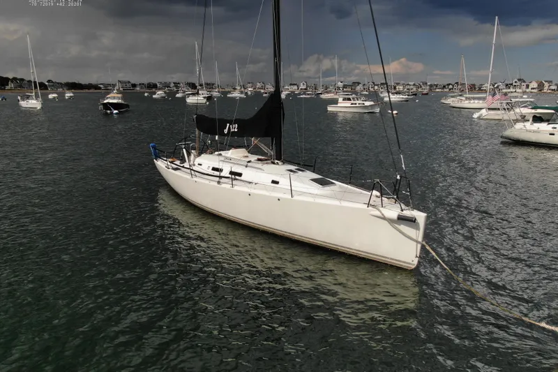 Slide: The Image of 2013 J Boats J/122 sailboat moored in a scenic harbor with cloudy skies. - 6