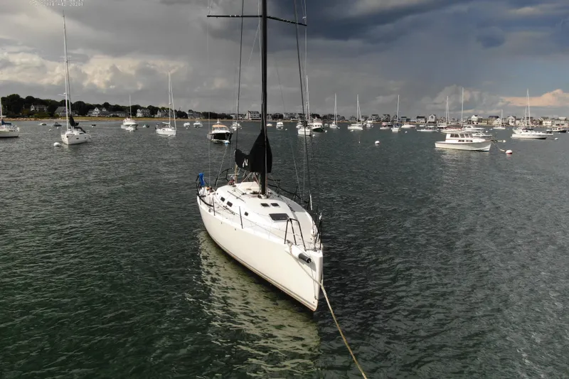 Slide: The Image of Sailboat J/122 from 2013 moored in a scenic harbor with cloudy skies. - 7