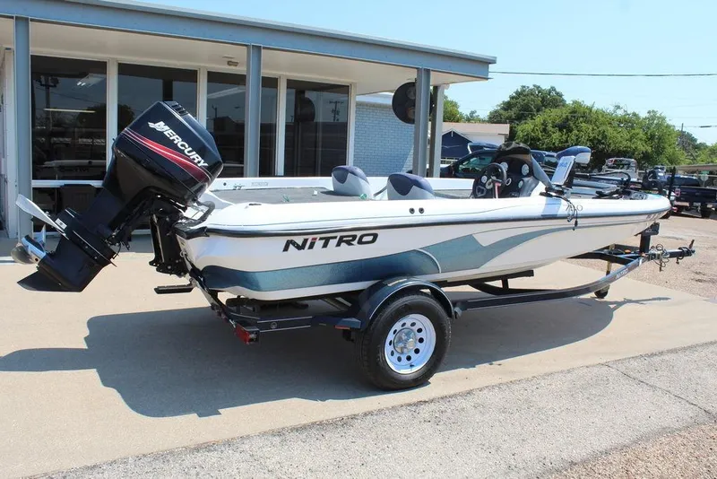 Slide: The Image of 2006 Nitro NX 750 boat with Mercury outboard motor on trailer, parked outdoors. - 4