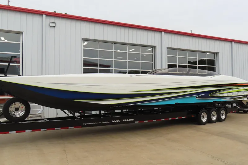 Slide: The Image of 2022 MTI 48 speedboat on trailer outside a garage, featuring sleek design and vibrant colors. - 30