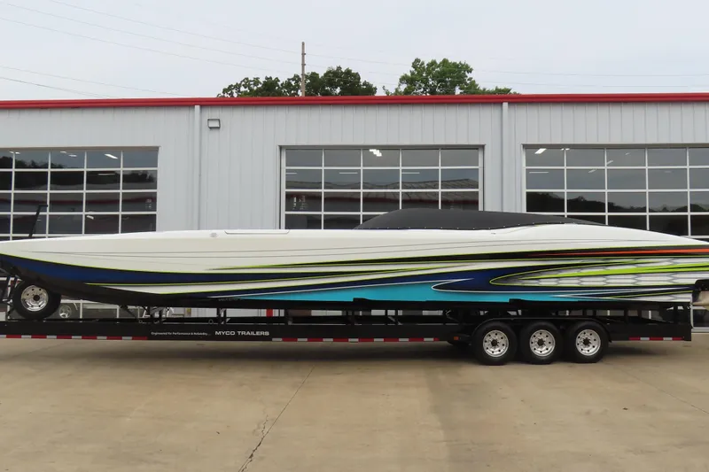 Slide: The Image of 2022 MTI 48 boat on trailer, vibrant design, parked outside a modern garage. - 32