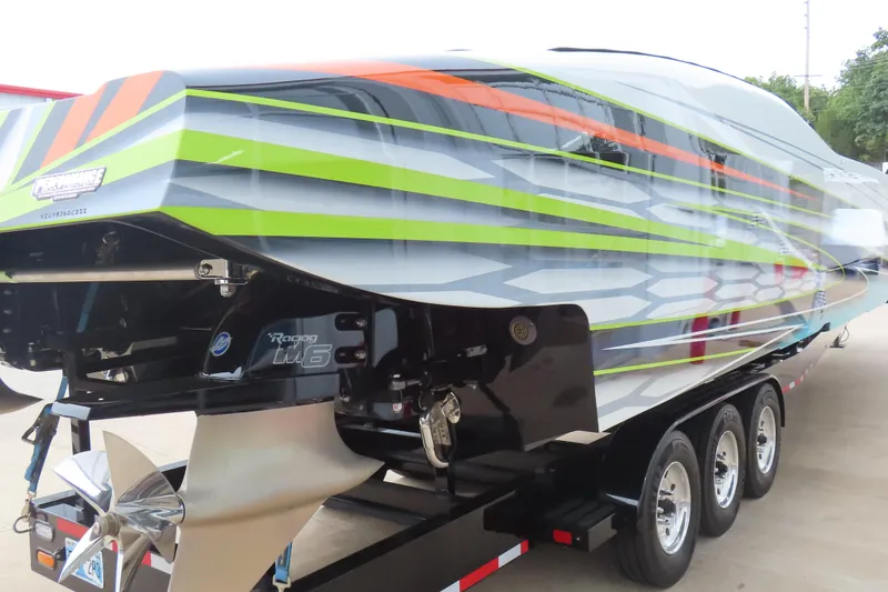 Slide: The Image of 2022 MTI 48 boat with vibrant stripes on a trailer, showcasing powerful engines. - 37