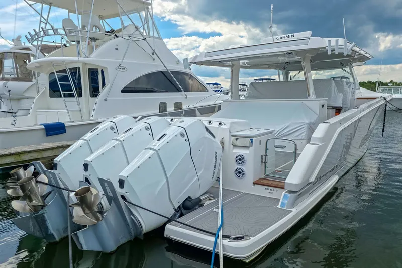 Slide: The Image of 2025 Regal 50 SAV luxury boat docked, featuring powerful outboard engines and sleek design. - 10