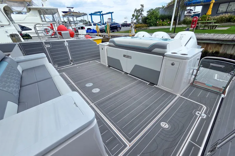 Slide: The Image of 2025 Regal 50 SAV boat deck with seating and modern design at a marina. - 13