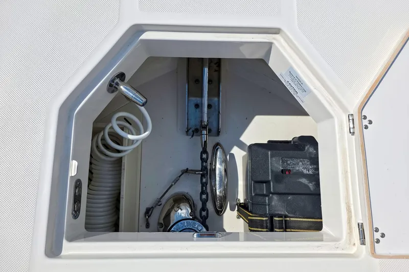 Slide: The Image of Anchor compartment of 2025 Regal 50 SAV boat with chain and coiled hose. - 24