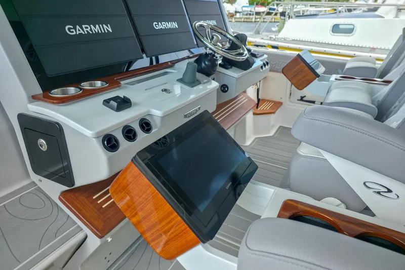 Slide: The Image of 2025 Regal 50 SAV boat cockpit with Garmin displays and luxurious seating. - 28