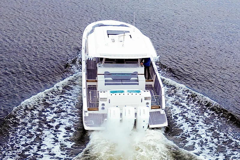 Slide: The Image of 2025 Regal 50 SAV yacht cruising on open water, rear view. - 3