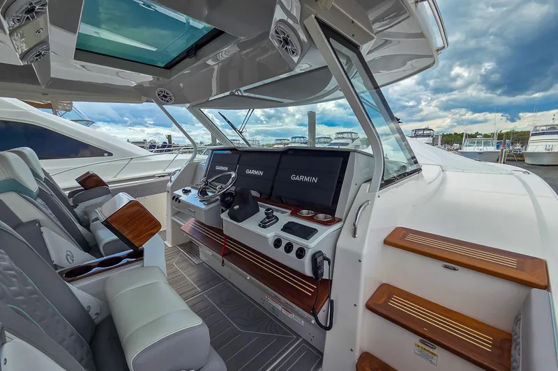 Slide: The Image of 2025 Regal 50 SAV yacht cockpit with Garmin navigation, luxurious seating, and modern design. - 36