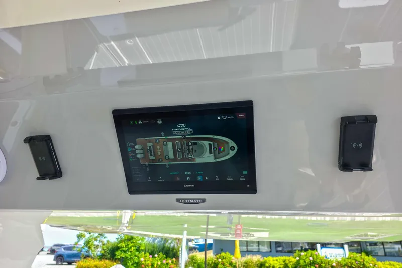 Slide: The Image of 2025 Regal 50 SAV yacht control panel with touchscreen display and wireless charging stations. - 39