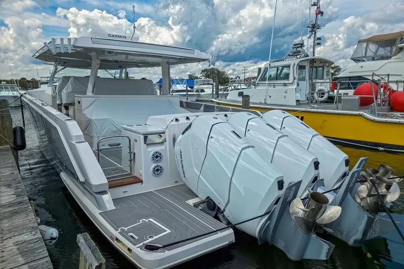 Slide: The Image of 2025 Regal 50 SAV boat docked, featuring powerful outboard engines and sleek design. - 8