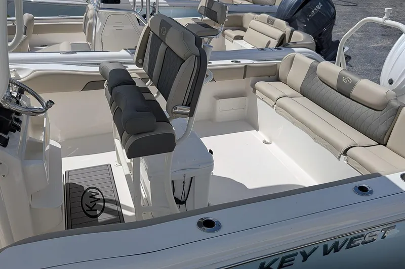 Slide: The Image of 2026 Key West 239 FS boat interior with cushioned seating and steering console. - 7