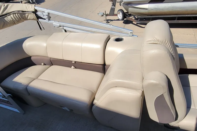 Slide: The Image of 2019 Sun Tracker Party Barge 24 DLX interior with beige seating and red panel. - 18