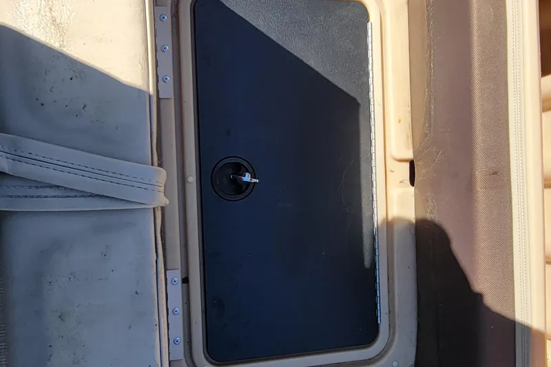 Slide: The Image of 2019 Sun Tracker Party Barge 24 DLX interior with open storage compartments and seating. - 23