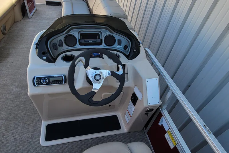 Slide: The Image of 2019 Sun Tracker Party Barge 24 DLX storage compartment with open seat and cup holder. - 24