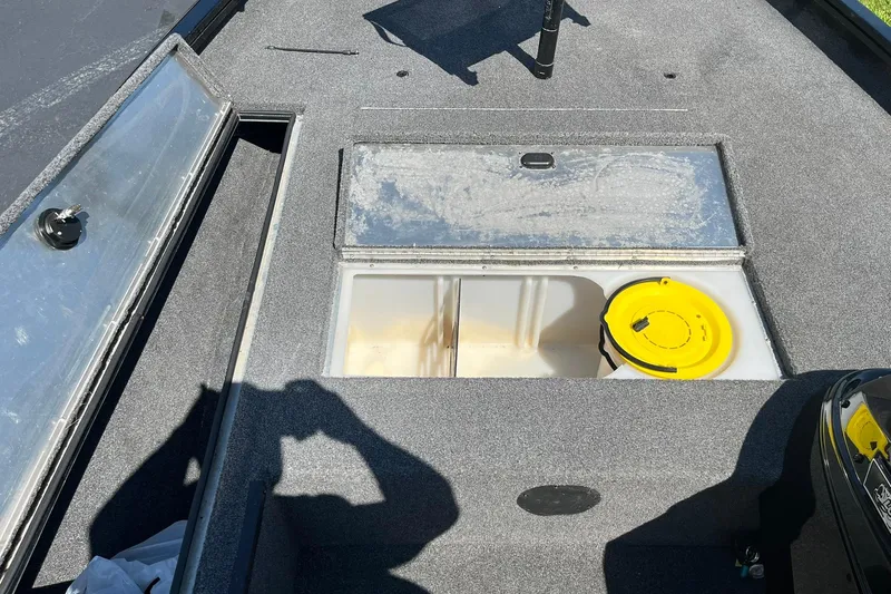 Slide: The Image of 2019 Lowe Stinger 175C boat interior with open storage compartments and yellow lid. - 16