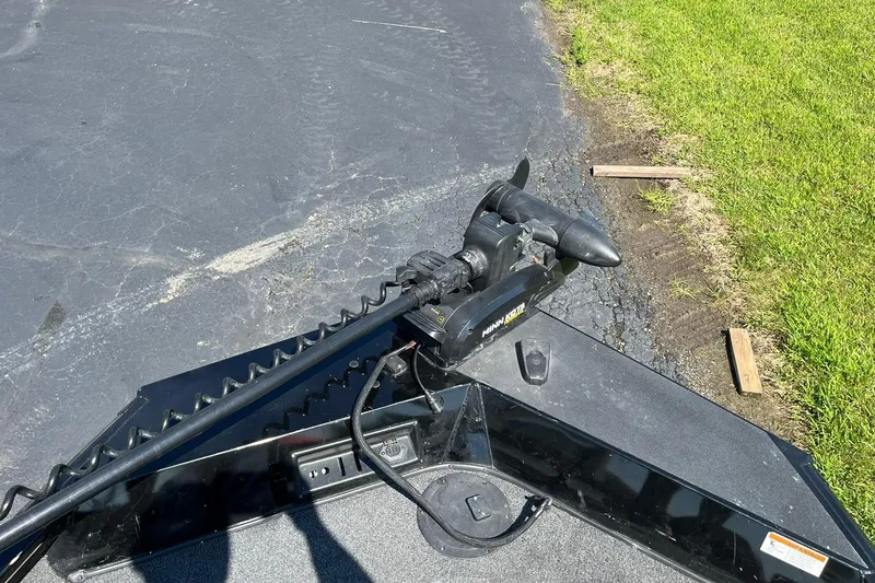 Slide: The Image of 2019 Lowe Stinger 175C boat with Minn Kota trolling motor on asphalt and grass. - 18