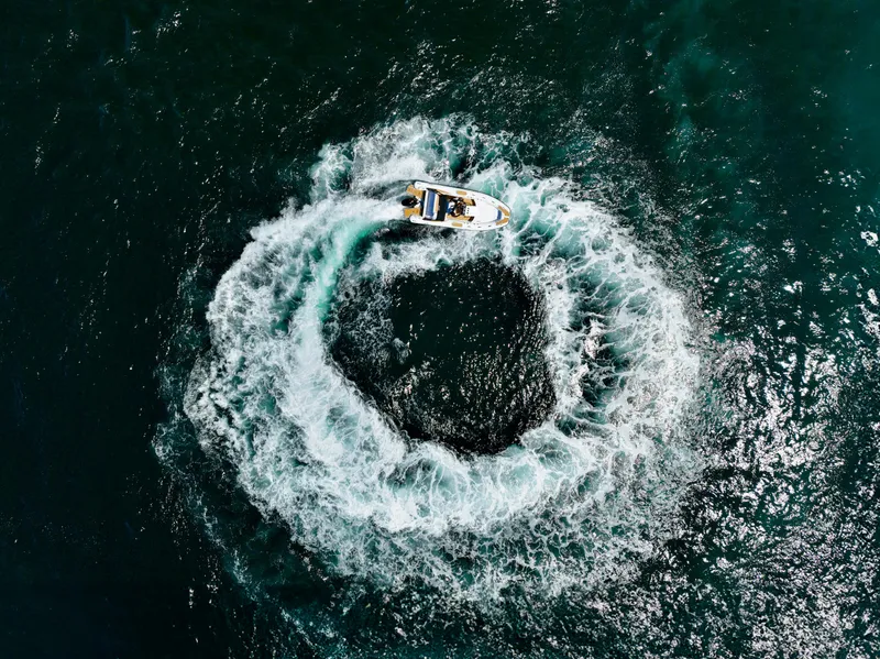 Slide: The Image of Aerial view of Aqvaboats Luxrib 22 (2025) creating circular waves in the ocean. - 33