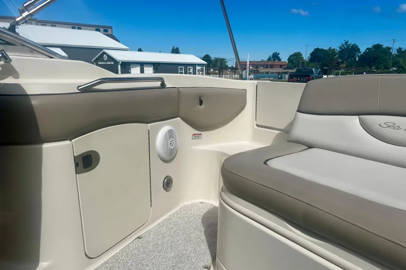 Slide: The Image of 2003 Searay 220 Sundeck interior with beige seating and storage compartments. - 10