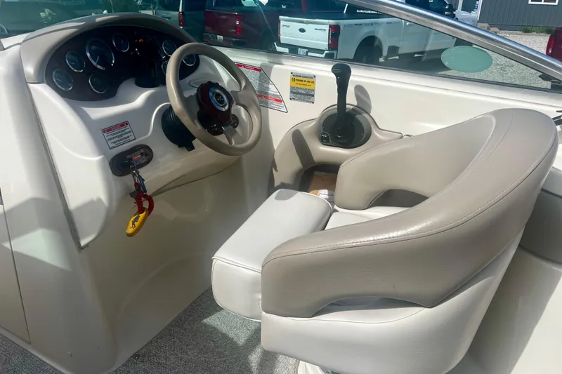 Slide: The Image of 2003 Searay 220 Sundeck boat cockpit with steering wheel and control panel. - 13