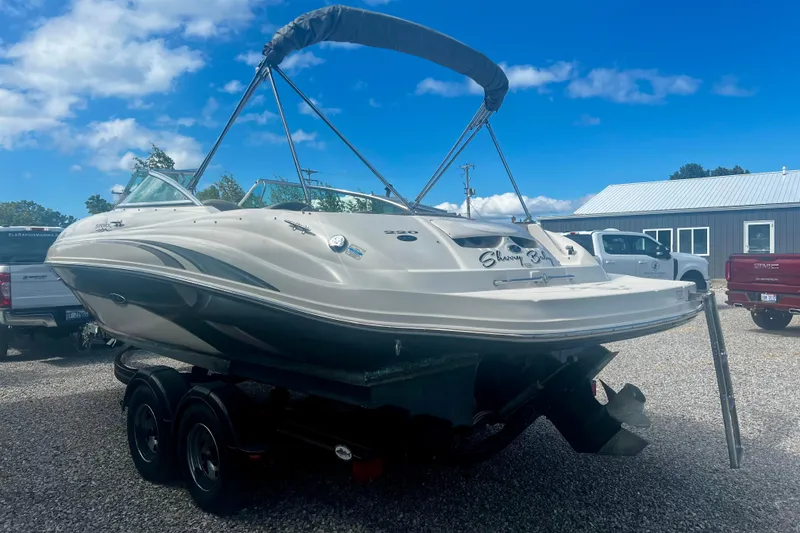 Slide: The Image of 2003 Searay 220 Sundeck boat on trailer under blue sky. - 5