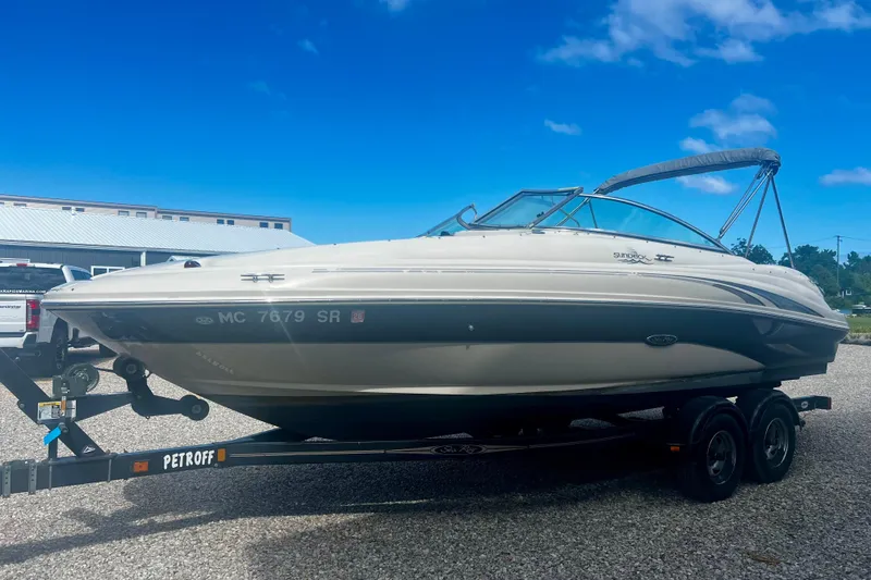 Slide: The Image of 2003 Searay 220 Sundeck boat on trailer under clear blue sky. - 7