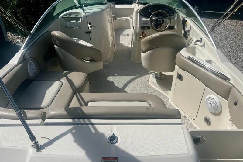 Slide: The Image of 2003 Searay 220 Sundeck interior with beige seating and steering console. - 9