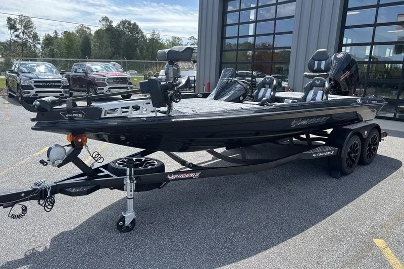 Slide: The Image of 2026 Phoenix 920 Elite X fishing boat on trailer, parked outdoors near vehicles. - 1