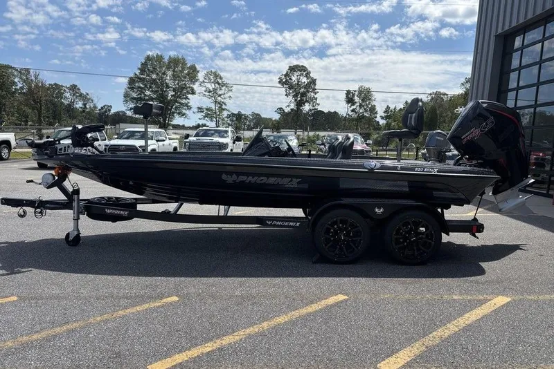 Slide: The Image of 2026 Phoenix 920 Elite X boat on trailer, parked outdoors under a clear sky. - 2