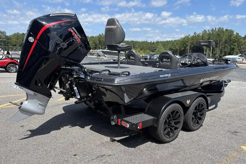 Slide: The Image of 2026 Phoenix 920 Elite X boat with powerful outboard motor in a parking lot. - 5