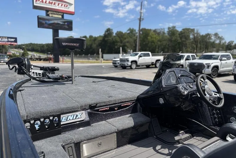 Slide: The Image of 2026 Phoenix 920 Elite X boat interior with steering wheel and dashboard, parked outdoors. - 9