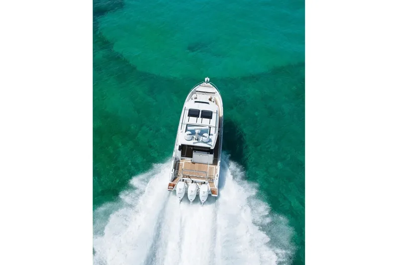 Slide: The Image of 2026 Wellcraft 38 Explorer yacht docked on a calm river under a cloudy sky. - 16