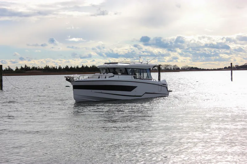 Slide: The Image of 2026 Wellcraft 38 Explorer boat on a serene waterway under a cloudy sky. - 41