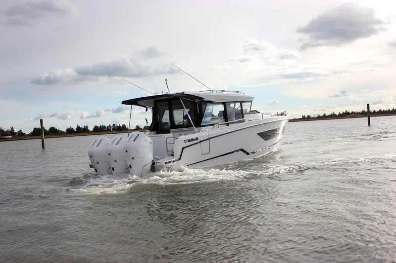 Slide: The Image of 2026 Wellcraft 38 Explorer boat cruising on a calm waterway under a cloudy sky. - 42