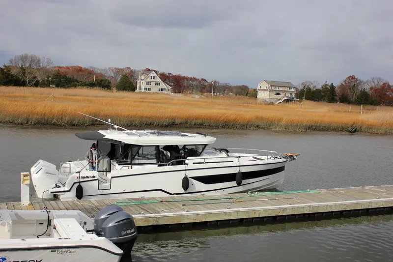 Slide: The Image of 2026 Wellcraft 38 Explorer docked by a scenic riverside with autumn foliage. - 49