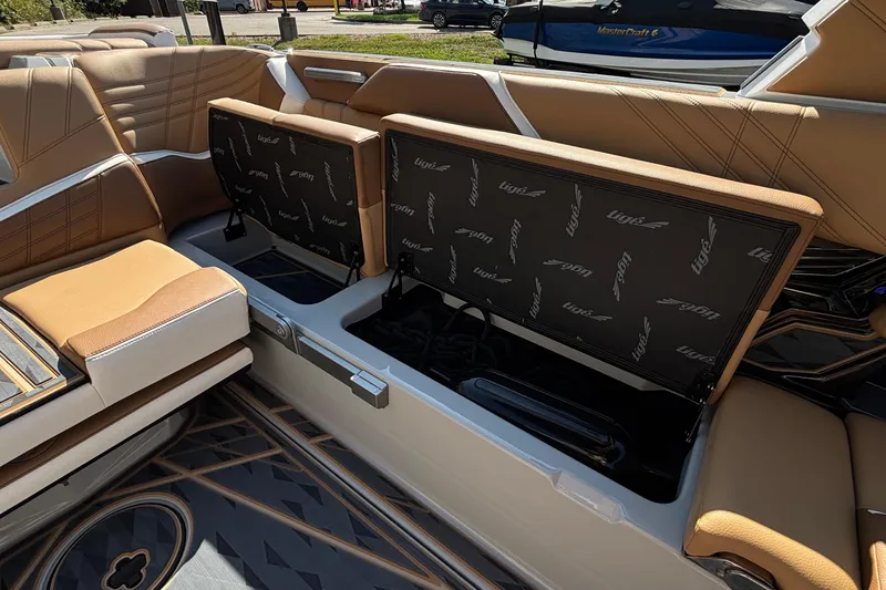 Slide: The Image of 2025 Tigé Ultré 25ZX boat interior with open storage compartments and tan seating. - 28