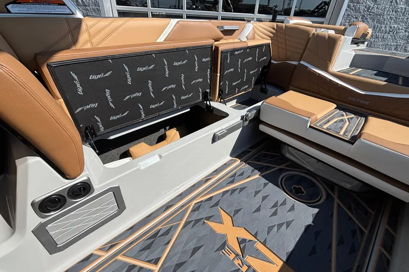 Slide: The Image of 2025 Tigé Ultré 25ZX boat interior with tan seating and storage compartments. - 29