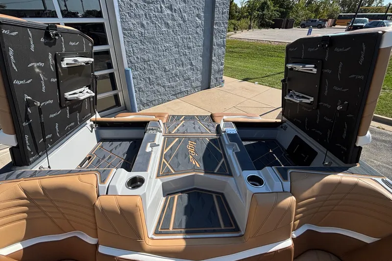 Slide: The Image of 2025 Tigé Ultré 25ZX boat interior with open storage compartments and luxurious seating. - 34
