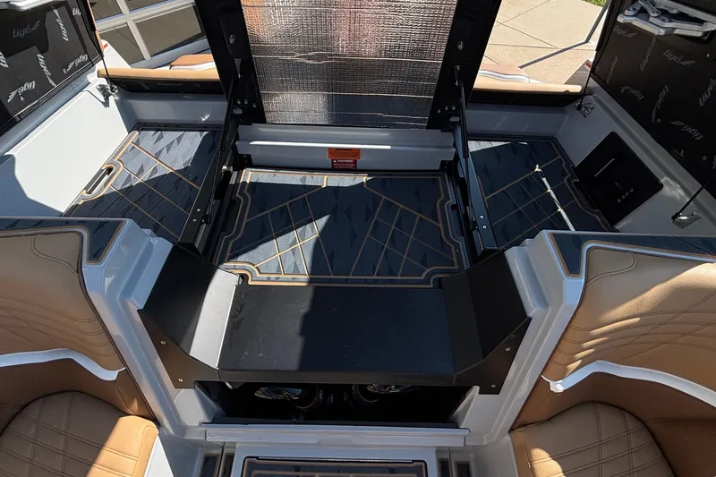 Slide: The Image of 2025 Tigé Ultré 25ZX boat interior with tan seating and storage compartments. - 35