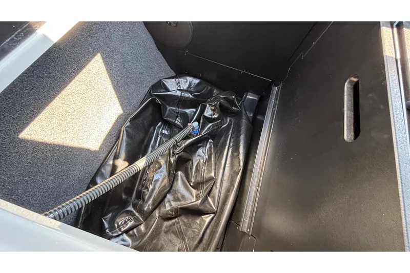 Slide: The Image of Storage compartment of 2025 Tigé Ultré 25ZX boat with black interior and hose. - 38