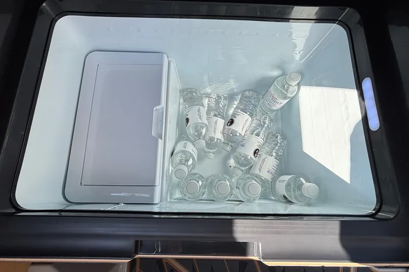 Slide: The Image of Cooler with water bottles inside the 2025 Tigé Ultré 25ZX boat. - 42