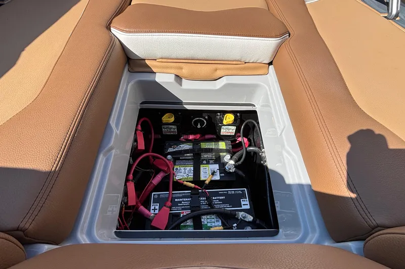 Slide: The Image of 2025 Tigé Ultré 25ZX boat battery compartment with brown leather seating. - 49