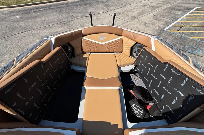 Slide: The Image of 2025 Tigé Ultré 25ZX boat interior with tan leather seating and storage compartments. - 54